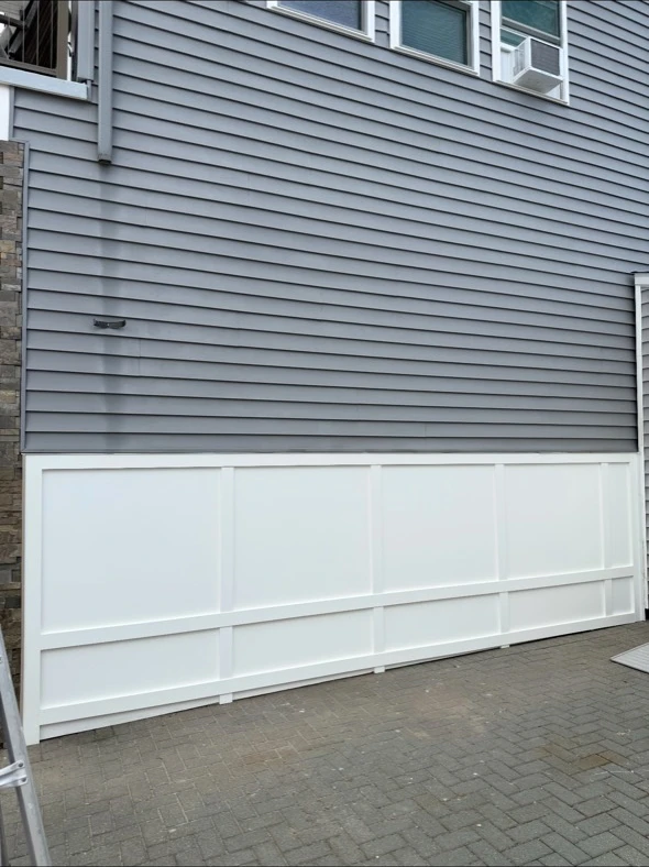 After: completed gray siding and white lower-wall panels